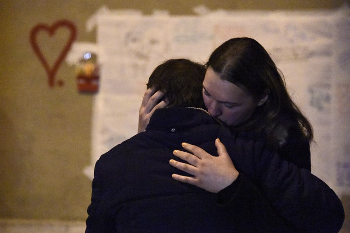 People comfort each other on Sunday during a gathering at a makeshift memorial in front of Le Carillon restaurant in Paris, where one of the attacks took place.