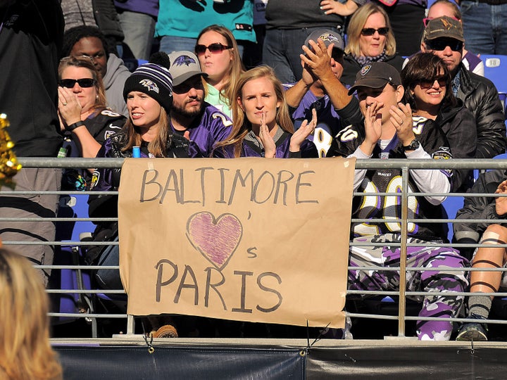 Baltimore Ravens fans (from left) Hannah Keegan, Emma Garman and Terry Keegan display a sign honoring the victims of the Paris attacks before the start of a game between the Baltimore Ravens and the Jacksonville Jaguars at M&T Bank Stadium in Baltimore.