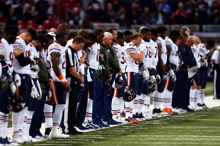 Chicago Bears players stand for a moment of silence before their game against the St. Louis Rams at the Edward Jones Dome in St. Louis, Missouri.