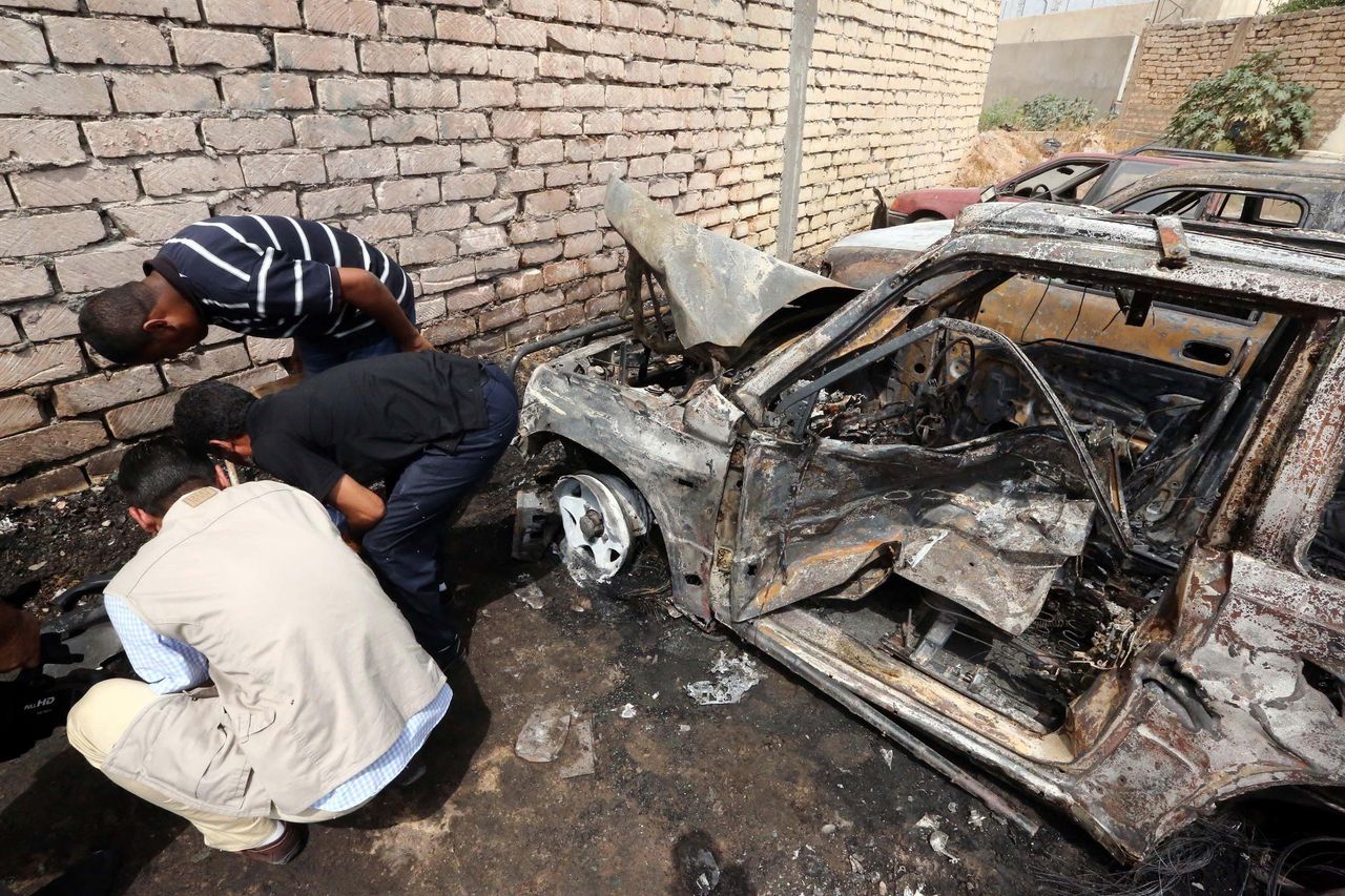 Crime scene investigation team members inspect the burnt wehicles at the site of car bombing attack, causing material damage but no casualties, near Hadba prison in Tripoli, Libya on September 09, 2015.