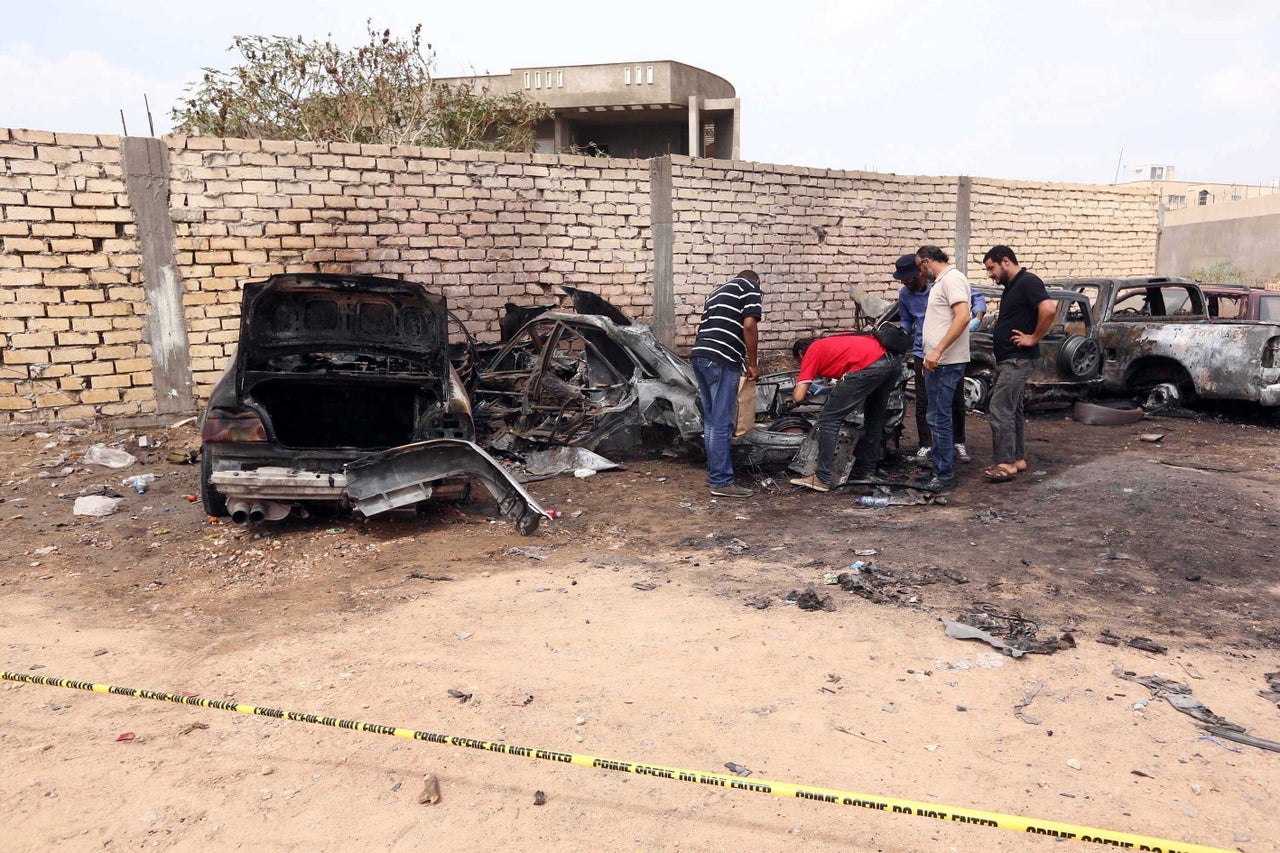 Crime scene investigation team members inspect the burnt wehicles at the site of car bombing attack, causing material damage but no casualties, near Hadba prison in Tripoli, Libya on September 09, 2015.