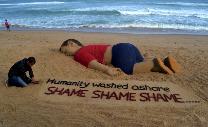 Indian artist Sudarsan Pattnaik works on a sand sculpture depicting drowned Syrian boy Aylan Kurdi on Sept. 4, 2015. 