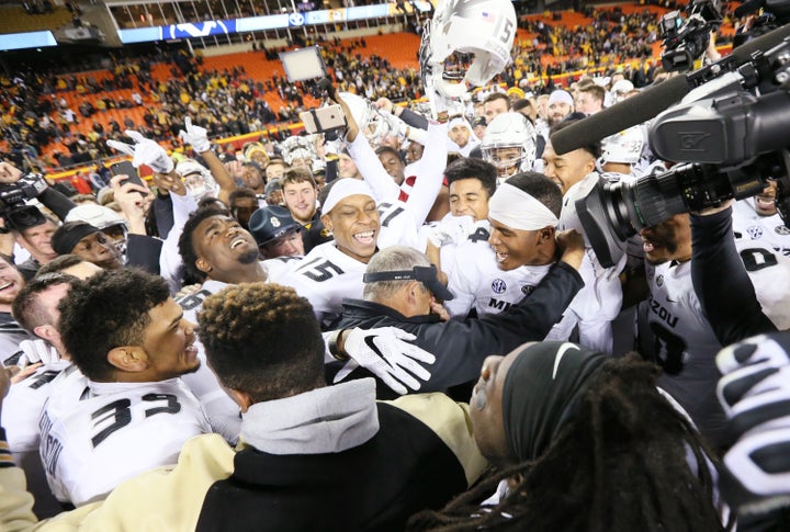 Pinkel, middle, wipes his eyes as his players chant his name after a 20-16 win against Brigham Young on Saturday, Nov. 14, 2015, at Arrowhead Stadium in Kansas City, Missouri.