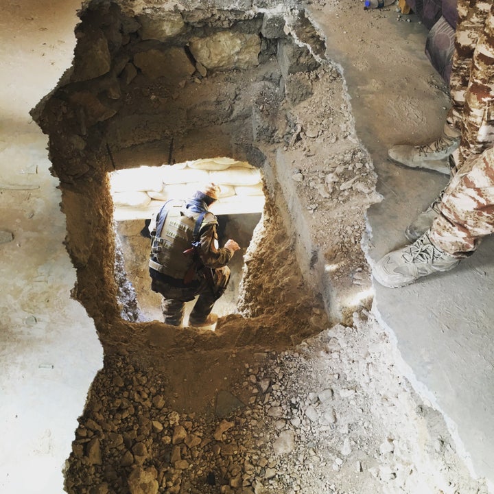 A Yazidi member of the local Asayesh security forces heads down a 65-foot-long ISIS tunnel, dug under a family home in Sinjar, Iraq.