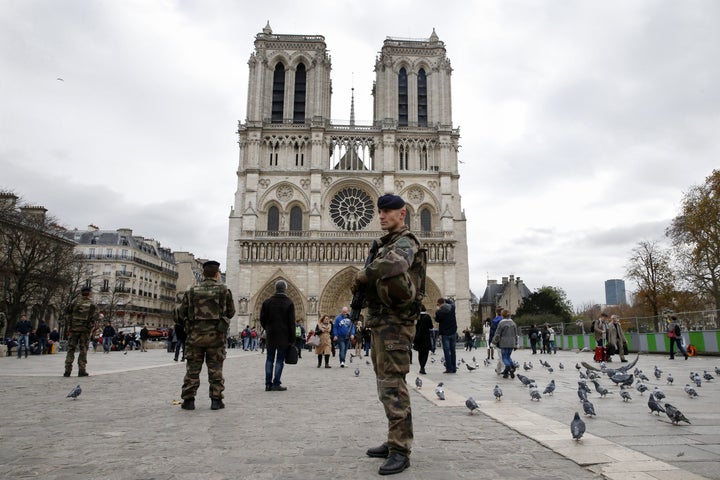 Soldiers patrol in front of the Notre Dame Cathedral on November 16, 2015 in Paris, ahead of a moment of silence for vic