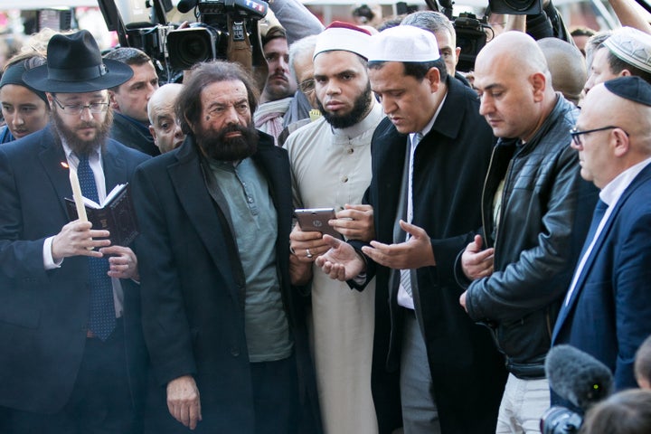 French imams join Jewish leaders outside the Bataclan theater to mourn and sing the French national anthem on Sunday, Nov. 15