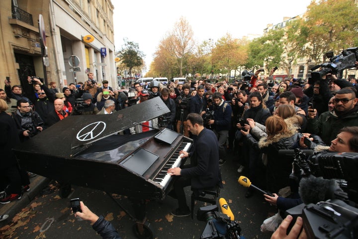 An unnamed man brings his portable grand piano and plays John Lennon's Imagine by the Bataclan, Paris.