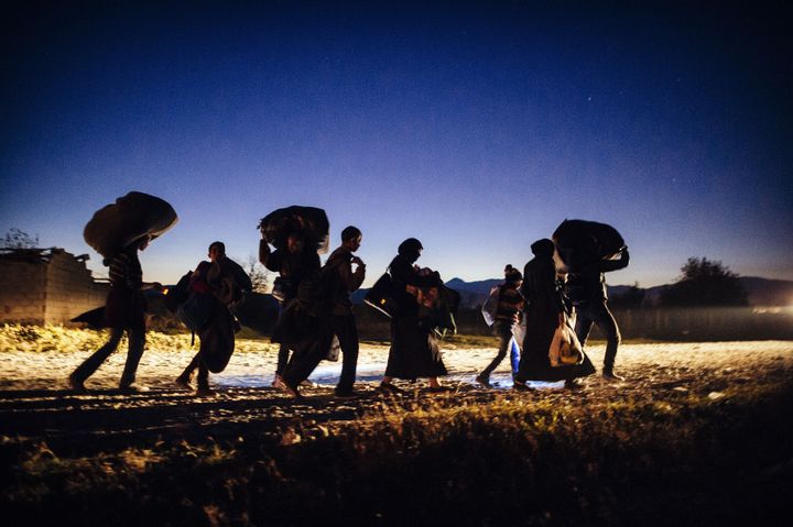 Migrants and refugees walk at nightfall after crossing the Greek-Macedonian border near Gevgelija on Nov. 13, 2015.