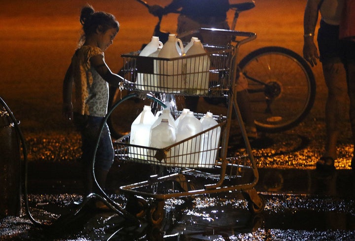 Filling the water jugs is a daily necessity for residents in the homeless camp. Kids often get the duty.