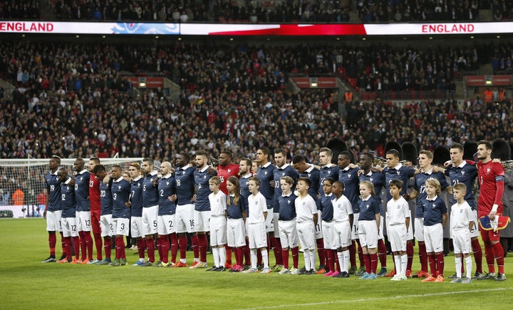 The France squad link arms before the start of the friendly football match between England and France at Wembley Stadium in west London on November 17, 2015.