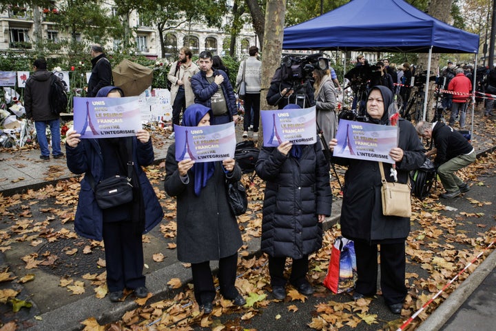 Muslim women hold placards against fundamentalism during the commemoration for victims of Paris terror attacks in front of Bataclan, Boulevard Voltaire in Paris, France on November 17, 2015.