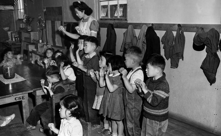 Aiko Sumoge, an assistant teacher, leads a kindergarten class singing an English folk song at the internment relocation center for Japanese-Americans in Tulelake, California, in May 1943.