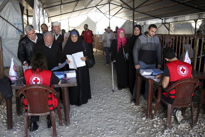 Syrian refugees line up to receive aid for the winter from the U.N. refugee agency in Tripoli, northern Lebanon, on Nov. 18,