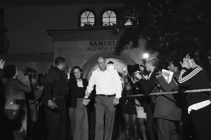 Occidental College President Jonathan Veitch is escorted out of a building where protesters had swarmed outside, calling for him to resign. 