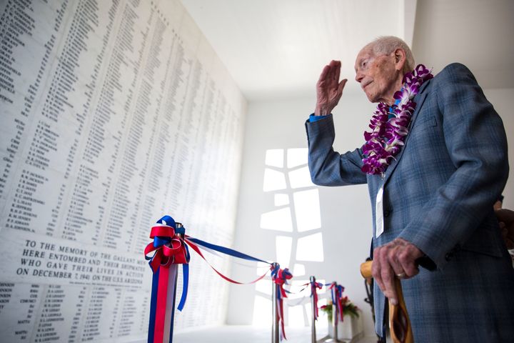 Pearl Harbor bombing survivor John Anderson salutes the remembrance wall of the USS Arizona shrine room during a memorial service for the 73rd anniversary of the attack on Pearl harbor in 2014. Anderson died Saturday at age 98.