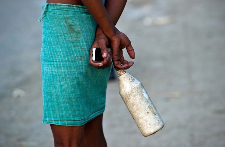 In this photograph taken on August 31, 2014, an Indian resident chats to others on his way home after defecating in an open field in a village in the Badaun district of Uttar Pradesh. Decorated with marigolds and ribbons, 108 toilets unveiled in a tragedy-hit village are a small step in Prime Minister Narendra Modi's push to end open-air defecation for impoverished Indian women.