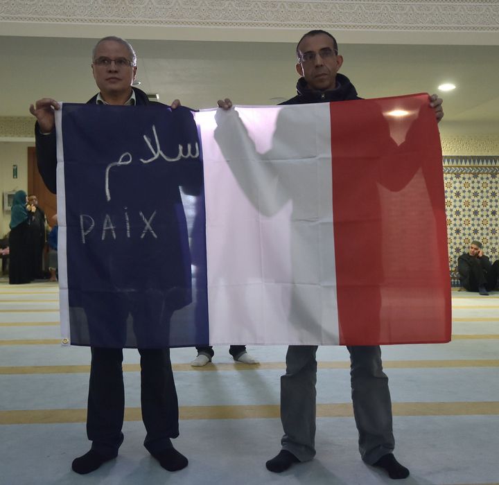 Muslims hold the French national flag at the Great Mosque of Strasbourg on Nov. 20, 2015 in Strasbourg, eastern France, during the Friday prayer, to pay tribute to the victims of the Nov. 13 Paris terror attacks.