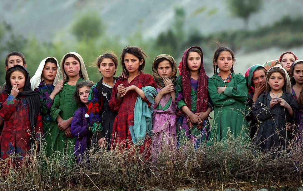 Girls from the remote village of Ghumaipayan Mahnow in northern Afghanistan, near the border with Tajikistan, watch as U.N. w