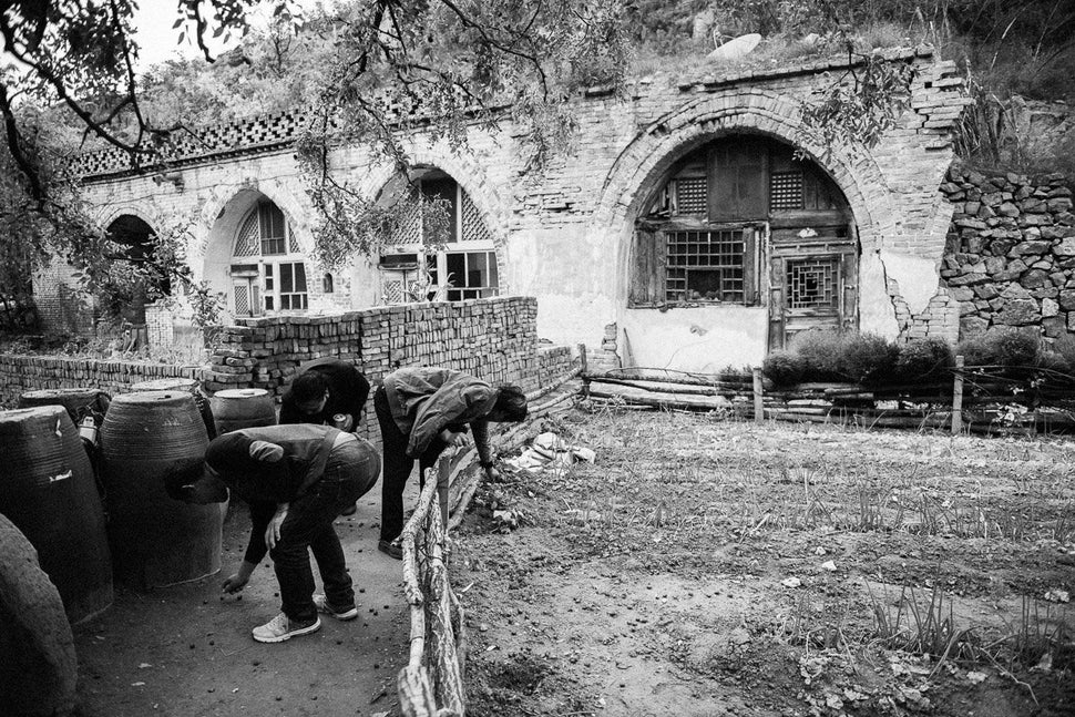 Liu and his son picking up dates outside the family's old home.