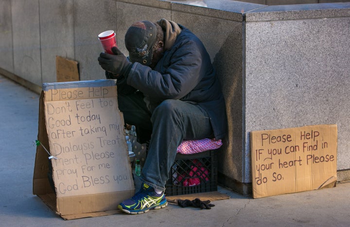 CHICAGO, IL - OCTOBER 10: A homeless man begs for money in front of the Wrigley Building on October 10, 2015 in Chicago, Illinois. Chicago, the third largest city in the United States River, continues to draw millions of international and domesic tourists each year.