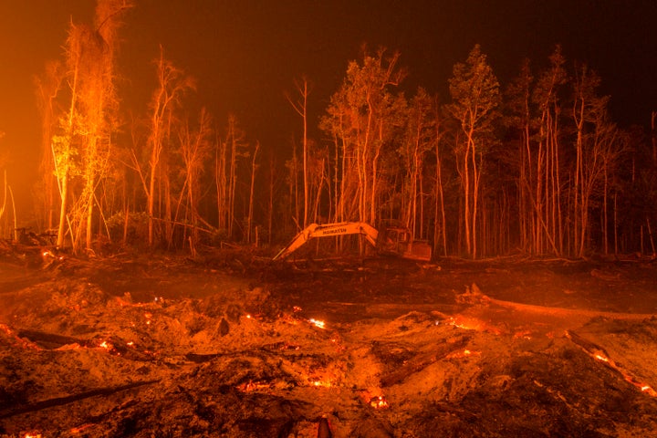 An excavator is seen as peatland forest is cleared by burning for a palm oil plantation at a company's grounds on November 1,