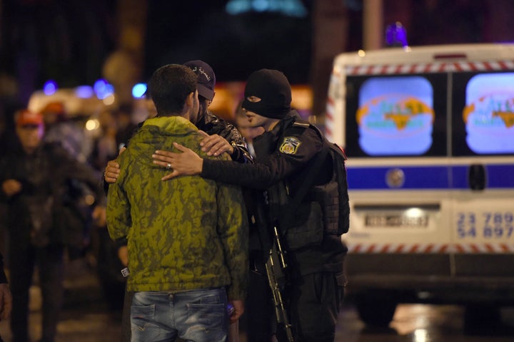 Tunisian police console a family member of one of the victims of the blast. At least 12 people were killed.