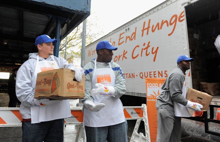 NEW YORK, NY - NOVEMBER 22: (L-R) New York Giants Team members Jim Cordle, Kevin Boothe and Chris Canty off load turkeys' as they prepare to deliver Thanksgiving dinners to residents of West Harlem at the Food Bank for New York City's Community Kitchen of West Harlem on November 22, 2011 in New York City.