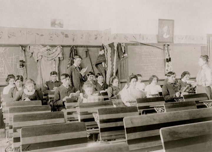 A 1901 classroom at Carlisle Indian Industrial School in Pennsylvania, a Native American boarding school. (Photo by Francis Benjamin Johnston/Buyenlarge/Getty Images)