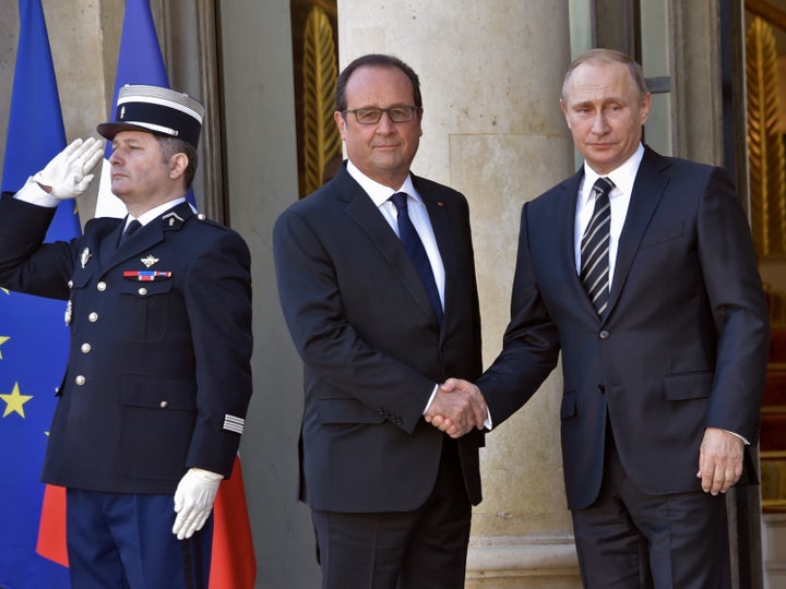 French President Francois Hollande (L) shakes hands with Russian President Vladimir Putin upon his arrival at the Elysee Palace on October 2, 2015 in Paris, France.