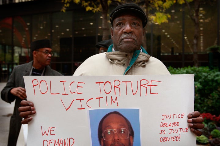 Aaron Cheney demonstrates outside the federal courthouse where former Chicago Police Commander Jon Burge was attending a hearing on charges he obstructed justice and committed perjury for lying while under oath during a 2003 civil trial about decades-old Chicago police torture allegations Oct. 27, 2008 in Chicago, Illinois. Burge cannot be charged for the torture of suspects because the federal statute of limitations for the crime has expired.