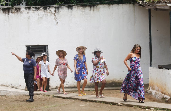 Inmate contestants walk toward the stage from a cellblock area