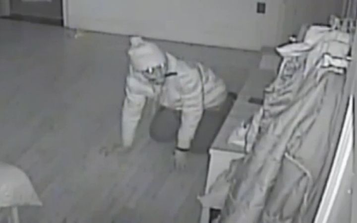 Video captured the brazen burglar crawling around the sleeping family's beds with a knife in his mouth.