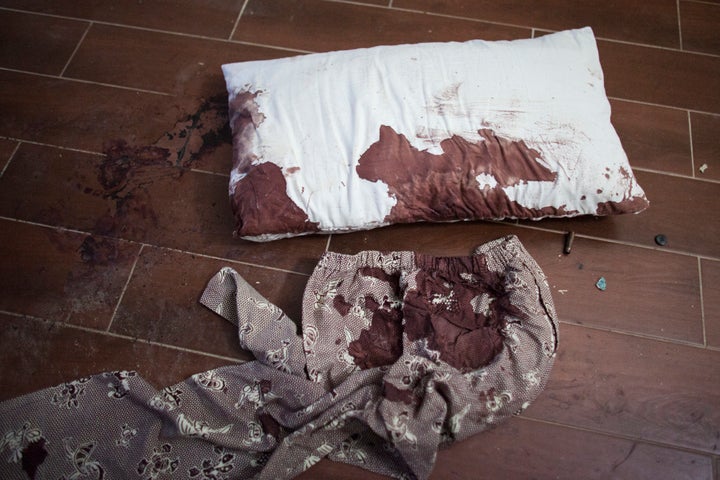 A blood stained pillow and pants lie on the floor next to bullet casings in a guest room of the Radisson Blu Hotel.