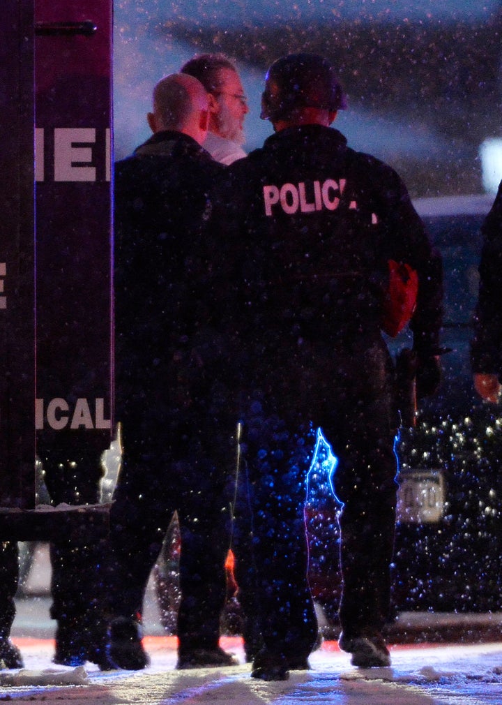 Police escort the shooting suspect out of an armored vehicle after the Planned Parenthood attack.