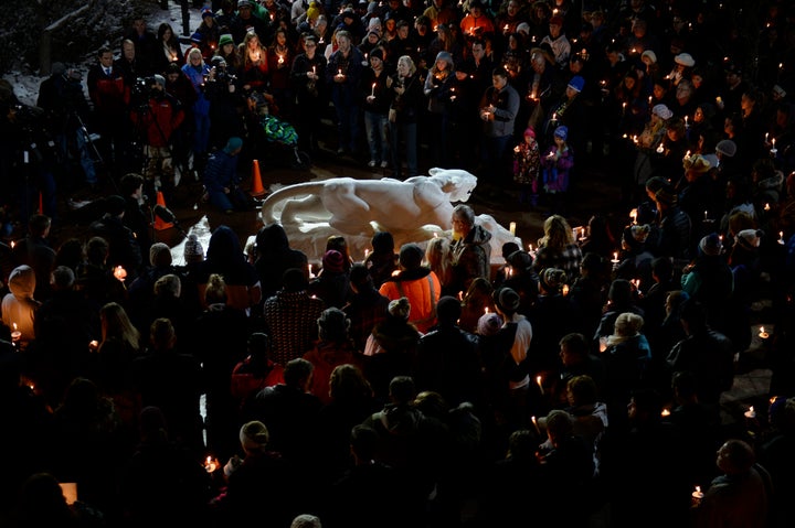 Hundreds gather around the University of Colorado at Colorado Springs Mountain Lion statue during a candlelight vigil at the