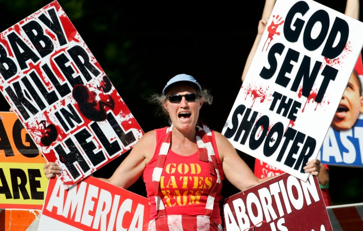 A demonstrator waits for abortion doctor George Tiller's casket to be taken to a hearse after his funeral services at College Hill United Methodist Church on Saturday, June 6, 2009, in Wichita, Kansas.