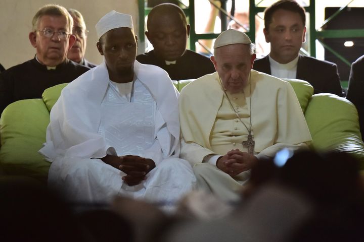 Pope Francis (C) looks on, alongside Imam Nehedid Tidjani (2-L), during a visit to the Central Mosque in Bangui on November 30, 2015. Pope Francis said on November 30 that Christians and Muslims were 'brothers', urging them to reject hatred and violence while visiting a mosque in the Central African Republic's capital which has been ravaged by sectarian conflict. 