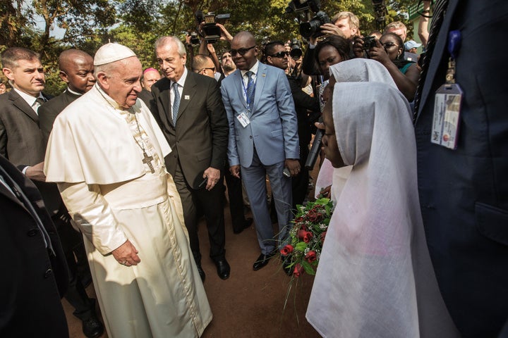 Pope Francis (L) arrives at the Central Mosque in the PK5 neighborhood to meet with members of the Muslim community on November 30, 2015 in Bangui. 