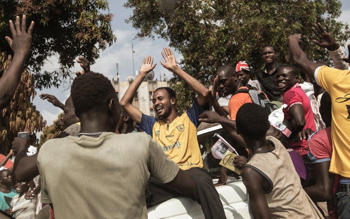 Muslims from the PK5 neighborhood are greeted by Christians, outside the Barthelemy Baganda stadium, ahead of the arrival of
