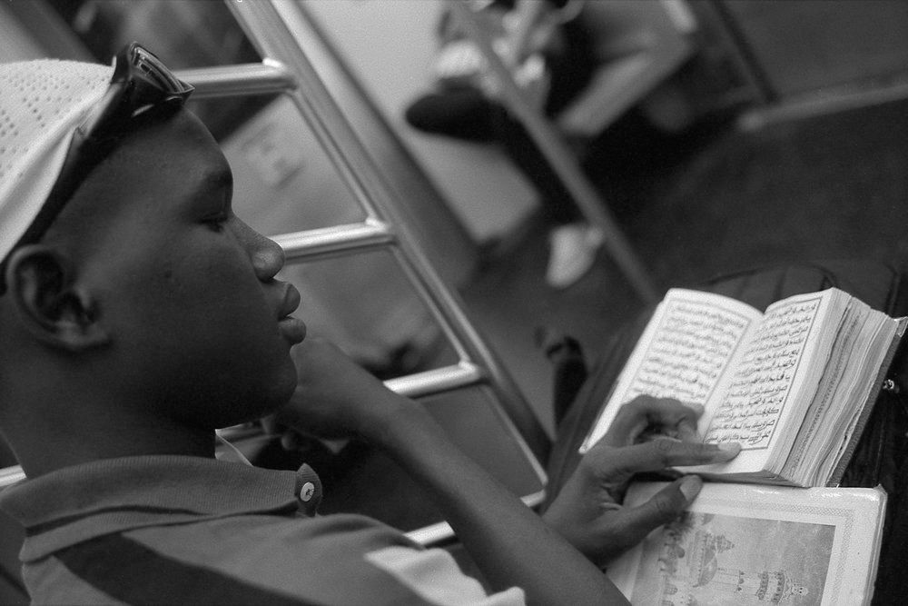Young Man Studying the Koran on the Uptown 6 Train, Manhattan, NY 2014