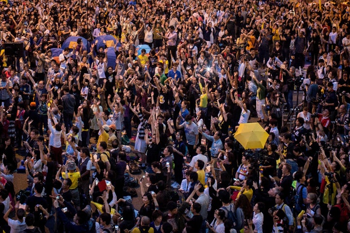 Pro-democracy activists hold up umbrellas and sing songs on a street outside Hong Kong's Government Complex in October 2014.