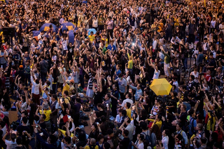 Pro-democracy activists hold up umbrellas and sing songs on a street outside Hong Kong's Government Complex in October 2014. 