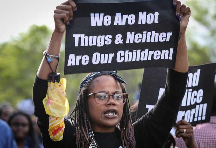 A protester holds a placard as she marches to the city hall, which is being protected by soldiers from the U.S. Army National Guard in Baltimore, Maryland, on April 30.
