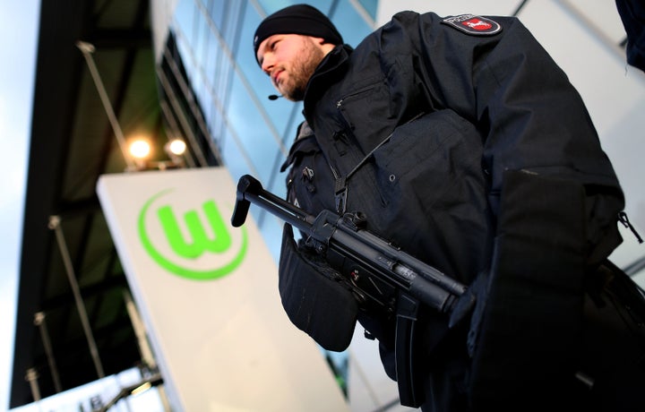 An armed German police officer guards the entrance of the Volkswagen Arena prior to a soccer match on November 21, 2015.