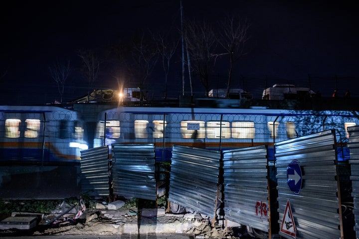 A metro passes as forensic officers work at the site of an explosion on Dec. 1 in Istanbul's Bayrampasa district.