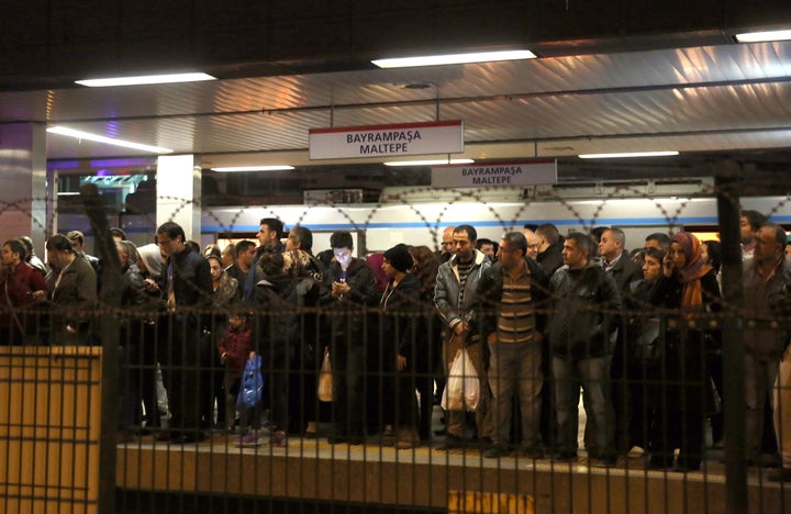 People wait outside Istanbul's Bayrampasa Metro Station after a blast occurred, reportedly due to an improvised pipe bomb, on