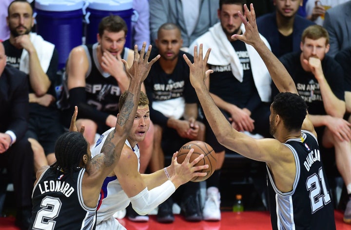 The Clippers' Blake Griffin looks to pass under pressure from the Spurs' Kawhi Leonard and Tim Duncan.