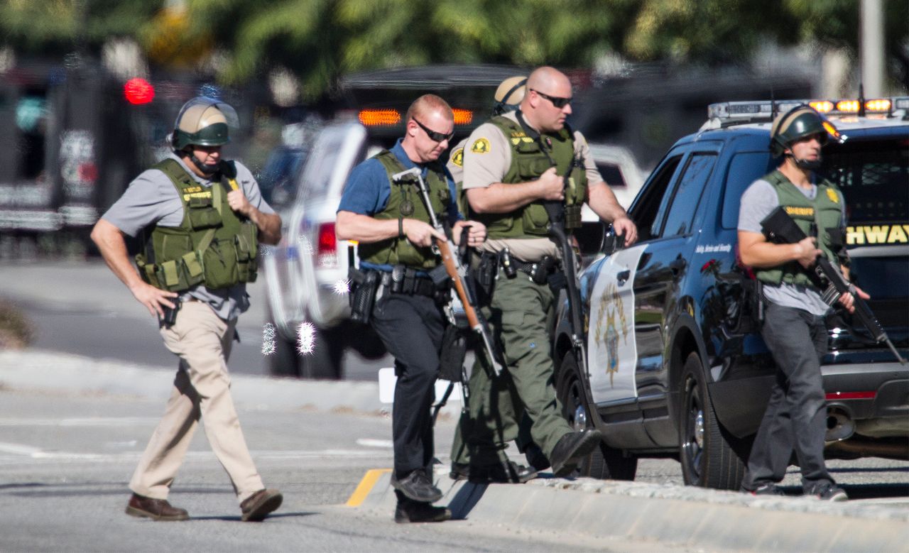 San Bernardino police officers in SWAT gear secure the scene.