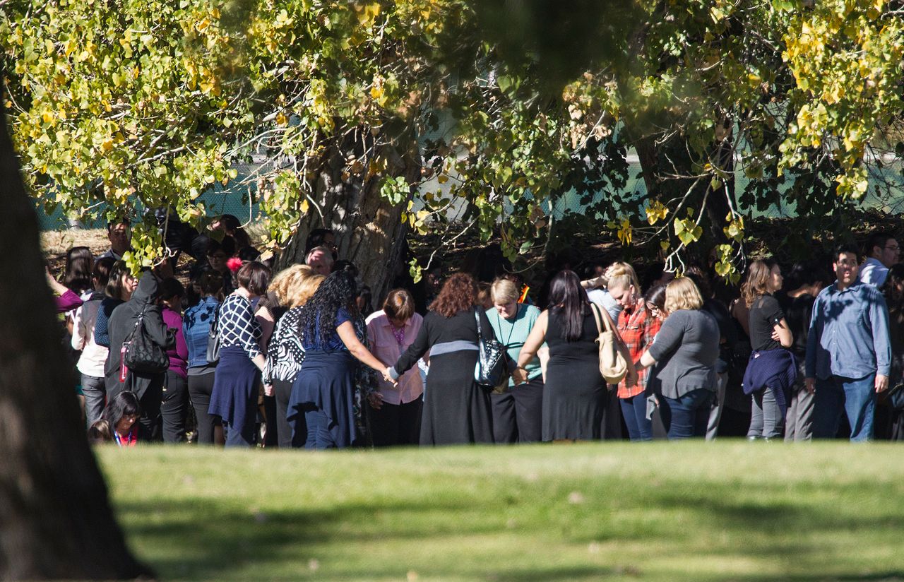 Evacuated workers pray in a circle on the San Bernardino Golf Course across the street where a mass shooting occurred at the Inland Regional Center on Dec. 2, 2015, in San Bernardino, California.