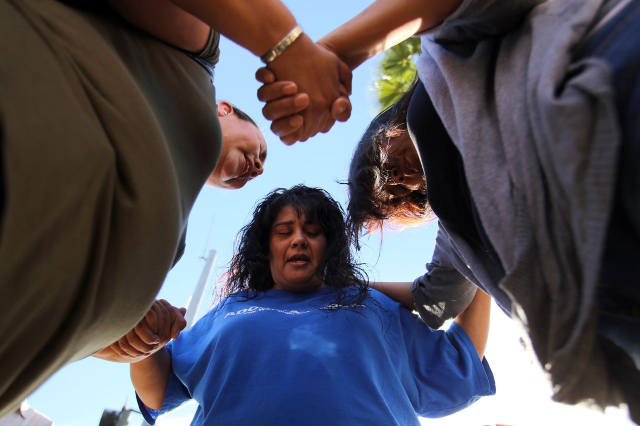Marie Cabrera, Sonya Gonzalez and Christine Duran, all of San Bernardino, pray after a mass shooting at the Inland Regional Center on Dec. 2, 2105 in San Bernardino, California.